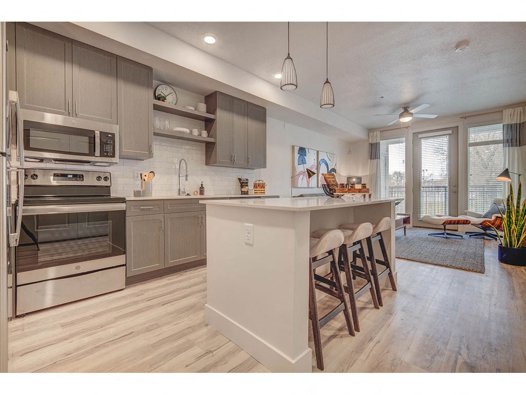 an open kitchen with a large island with chairs