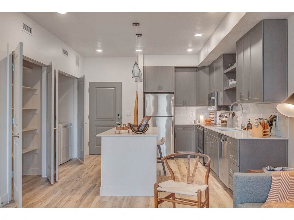 a kitchen with a table and a chair and a refrigerator