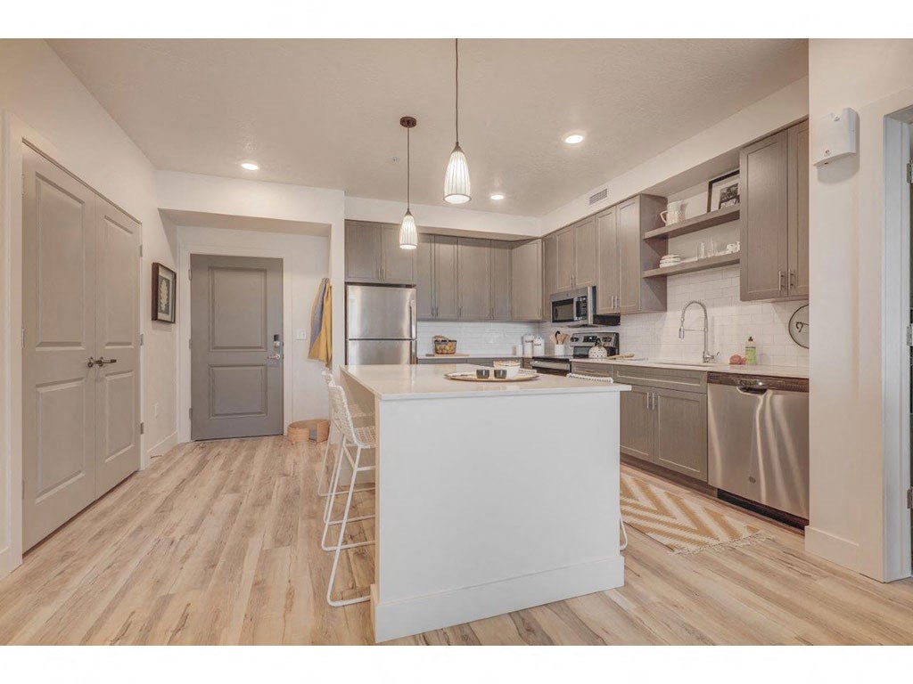a large kitchen with a white island and stainless steel appliances