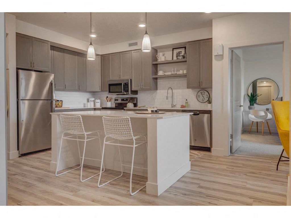 a kitchen with an island and yellow chairs