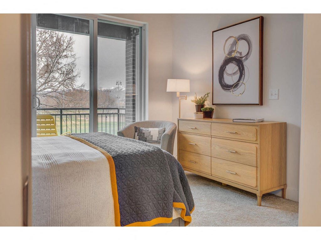 a bedroom with a bed and a dresser and a window