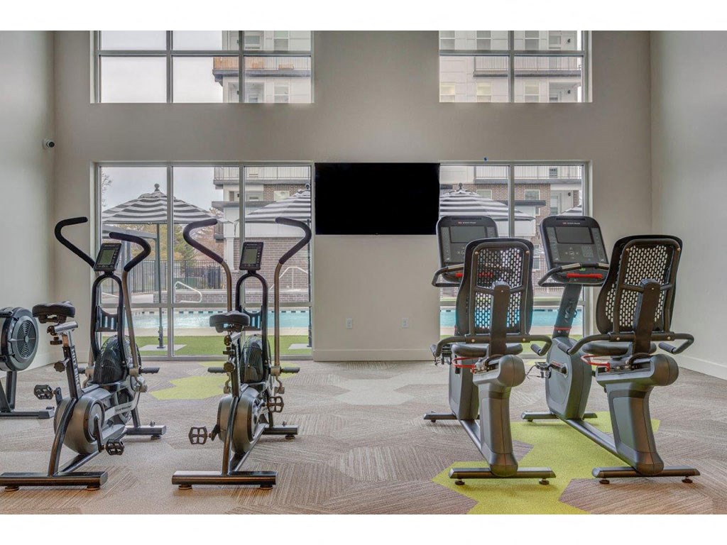 a gym with a pool and exercise equipment in a room
