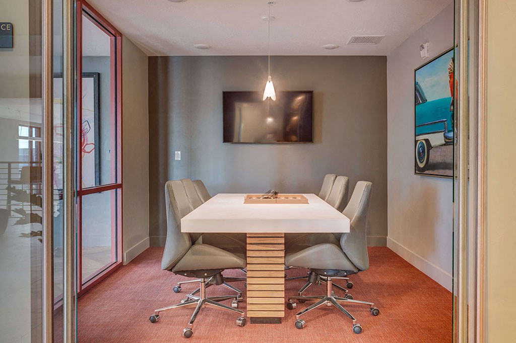 a conference room with a white table and chairs