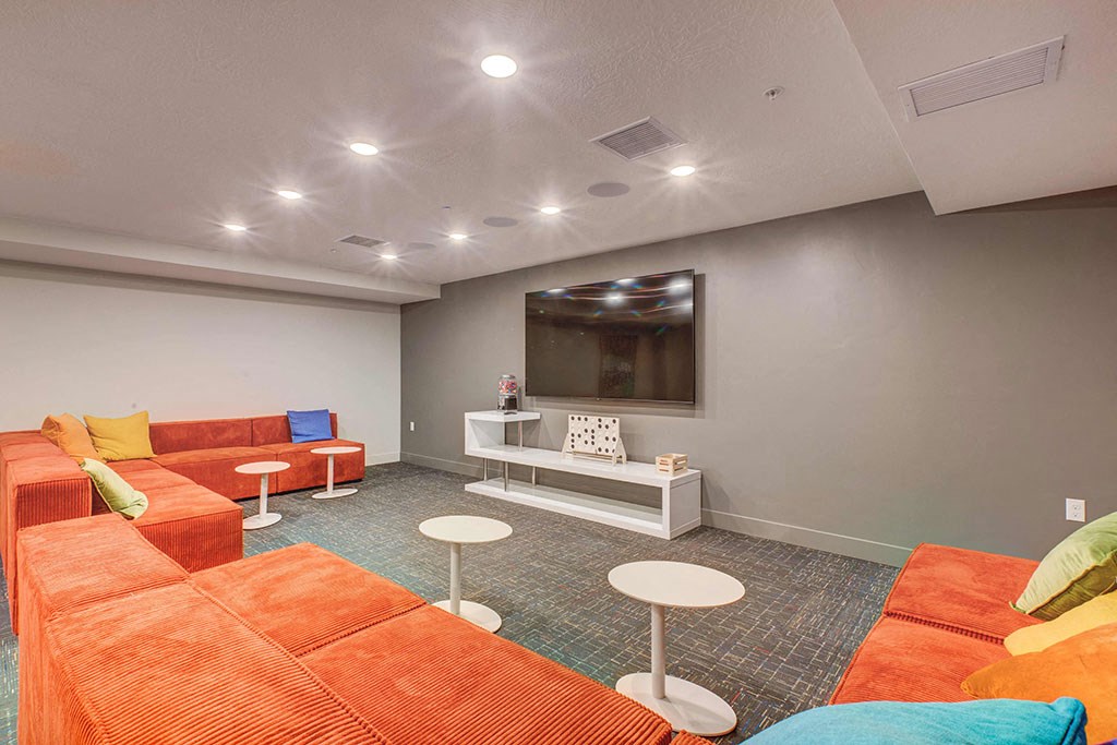 a living room with orange couches and a television