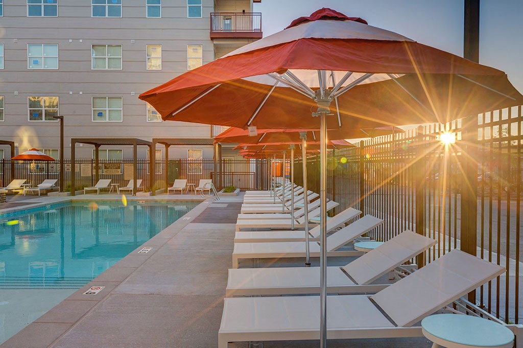 a pool with lounge chairs and umbrellas at a hotel