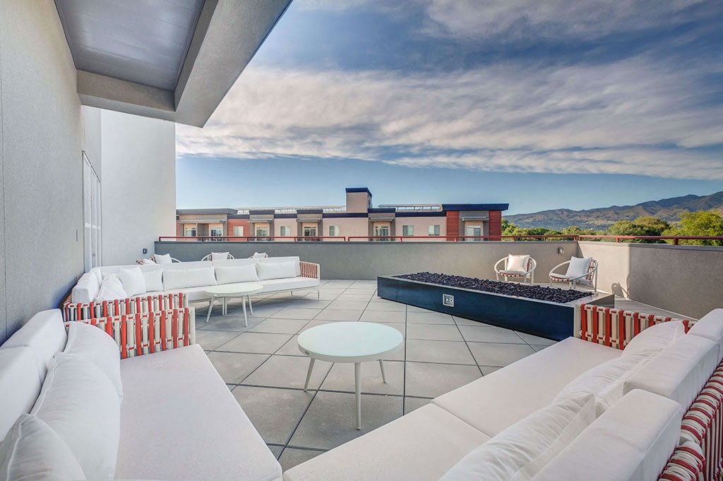 a living room with couches and a table on a balcony
