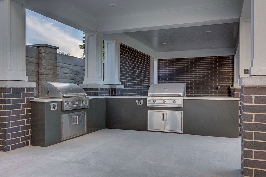 a covered outdoor kitchen with two stainless steel appliances