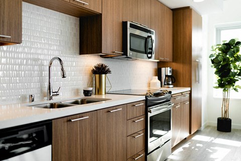 a kitchen with wooden cabinets and a sink and a microwave