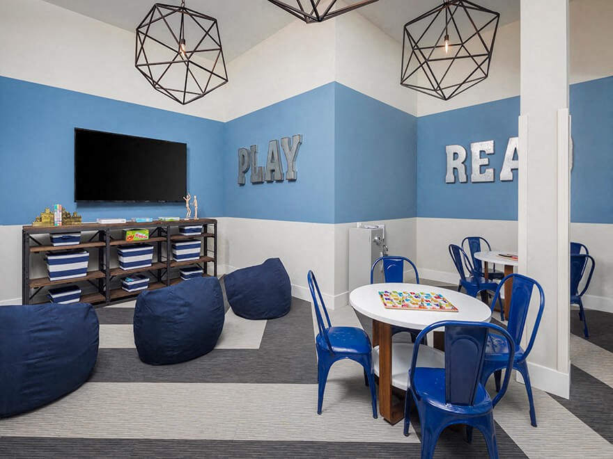 a play room with a table and chairs and a tv
