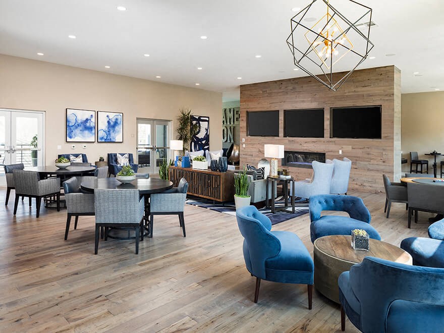 a living room with blue chairs and tables and a fireplace