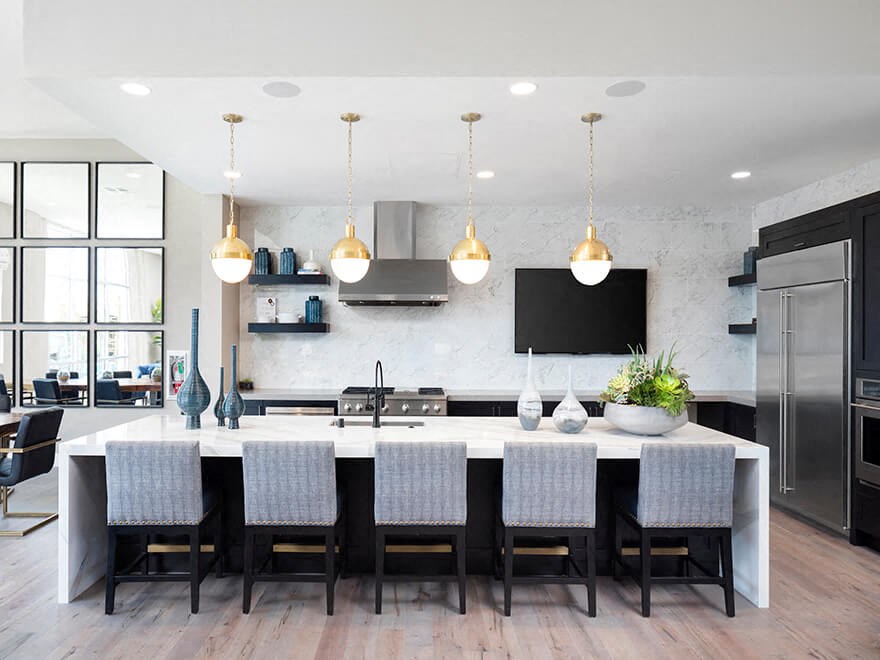 a large kitchen with a large white island and chairs