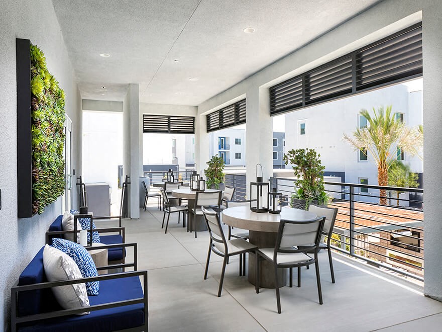 a living room with a table and chairs and a balcony