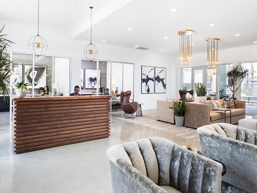 the lobby of a hotel with couches and a reception desk