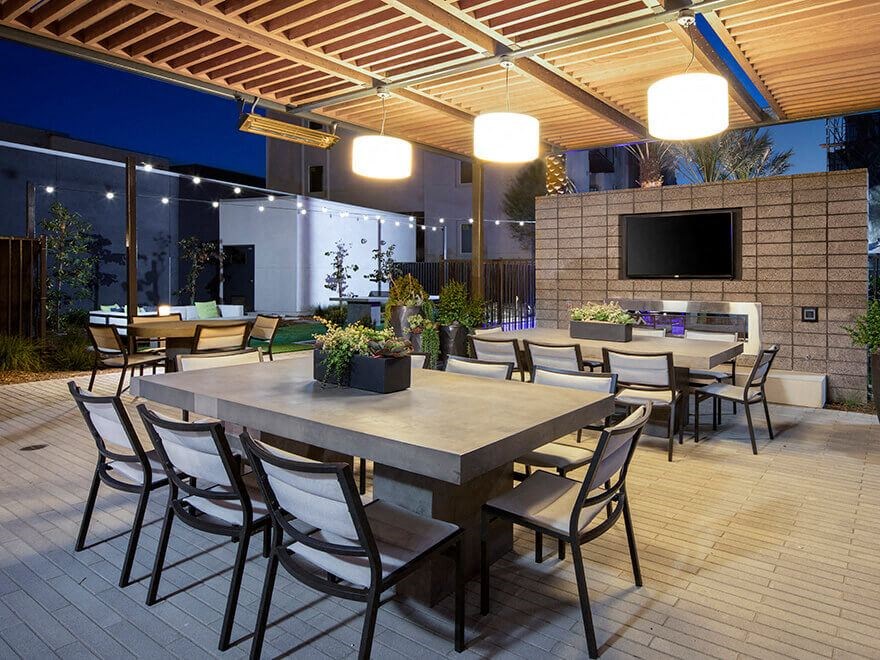a large patio with tables and chairs and a tv