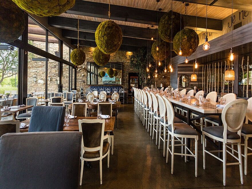 a restaurant with rows of tables and chairs and lamps