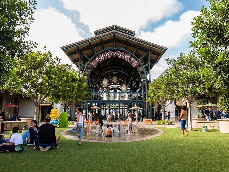 people playing in a fountain in front of a building