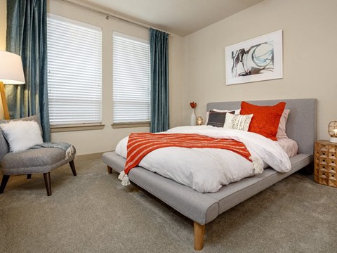a bedroom with a bed and two windows