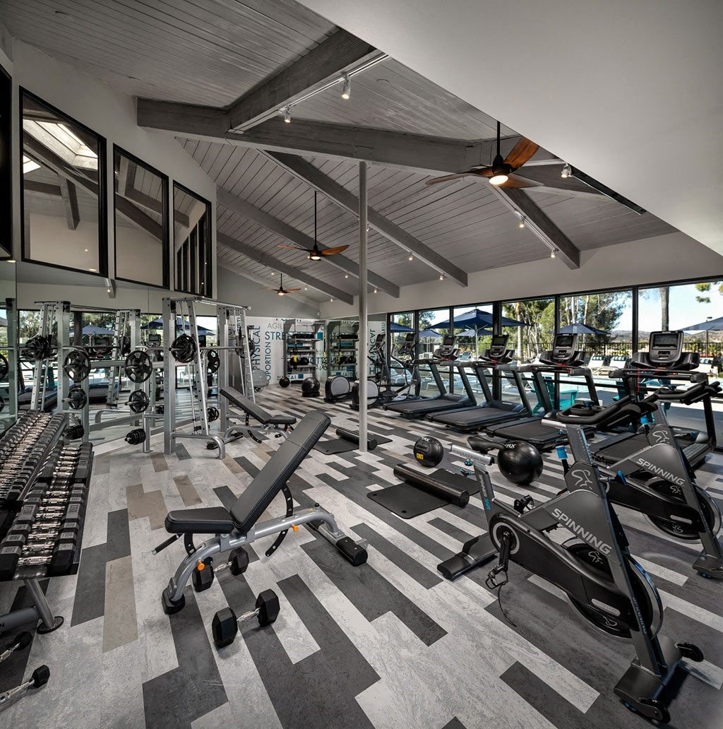 a gym with work out machines and windows