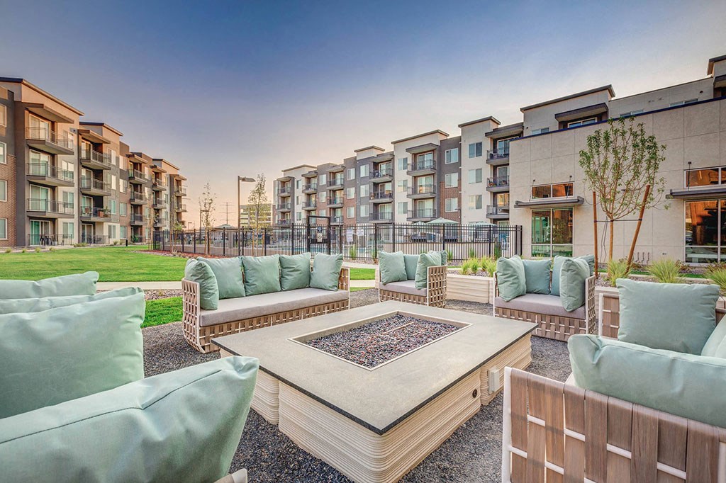 an apartment patio with furniture and a fire pit