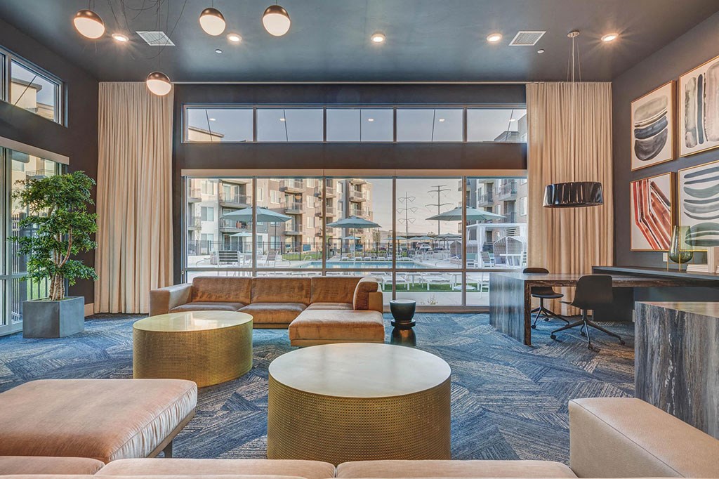 a lobby with couches and tables and a large window