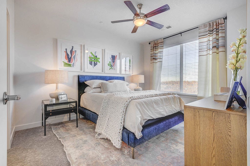 a bedroom with a bed and a ceiling fan