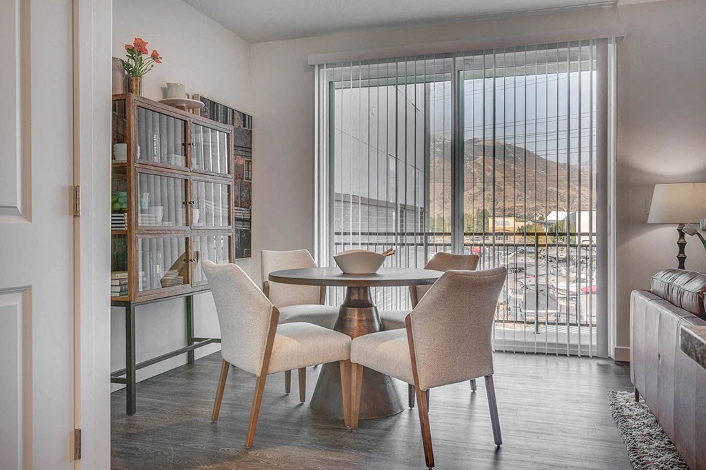 a dining room with a table and chairs in front of a window