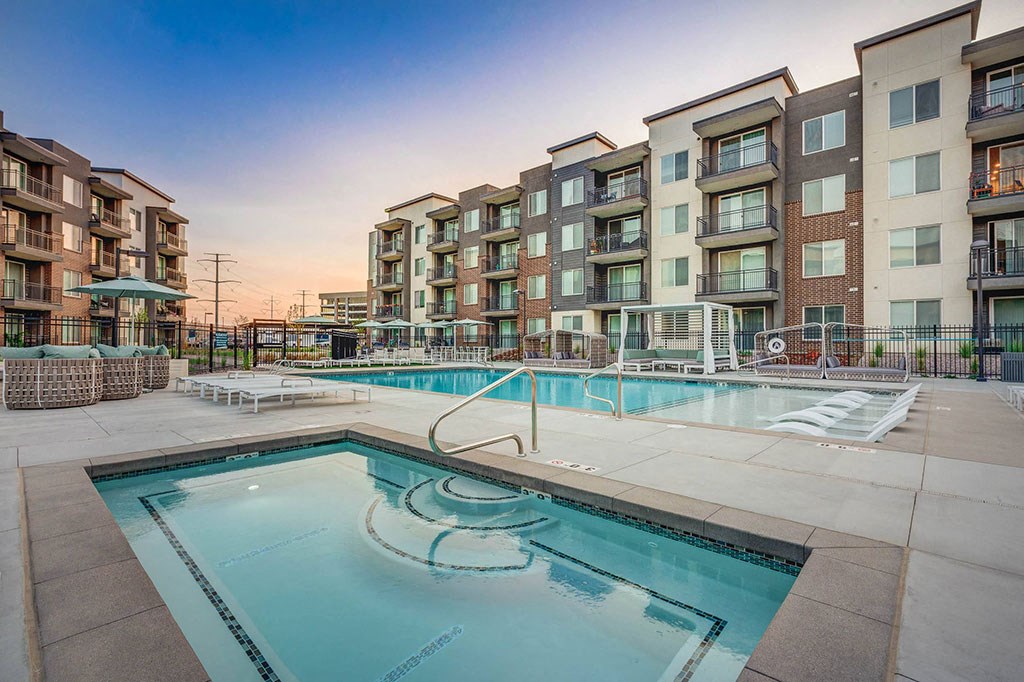 a swimming pool with an apartment building in the background