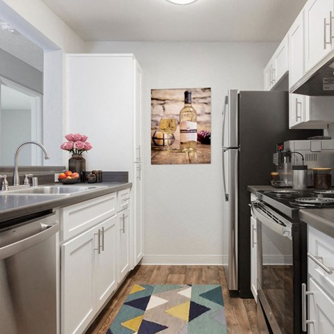 a kitchen with white cabinets and a refrigerator and a sink