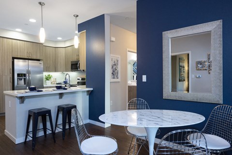 a dining room and kitchen with a marble table and chairs