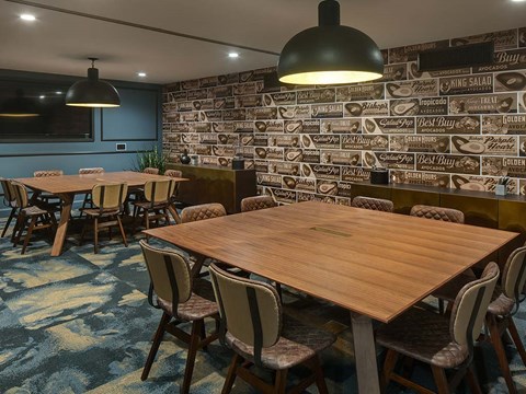 a dining room with tables and chairs and a wall covered in graffiti
