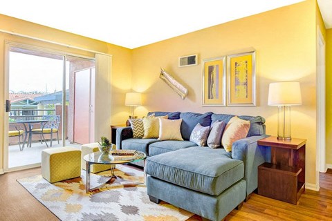 a living room with a blue couch and a sliding glass door