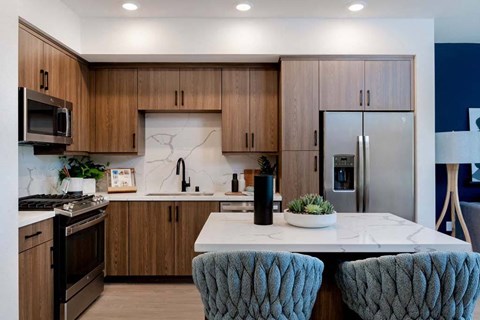 a kitchen with wooden cabinets and a marble counter top