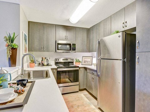 a kitchen with stainless steel appliances and white counter tops