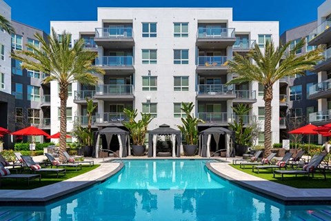 a large swimming pool in front of an apartment building