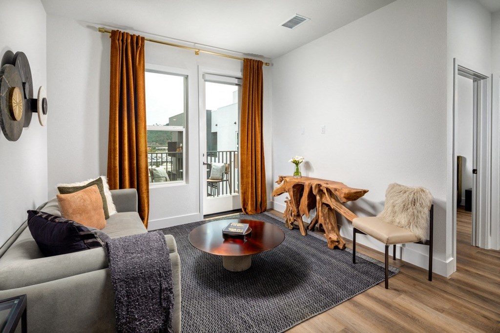 A living room with a grey couch, a coffee table, and a chair.