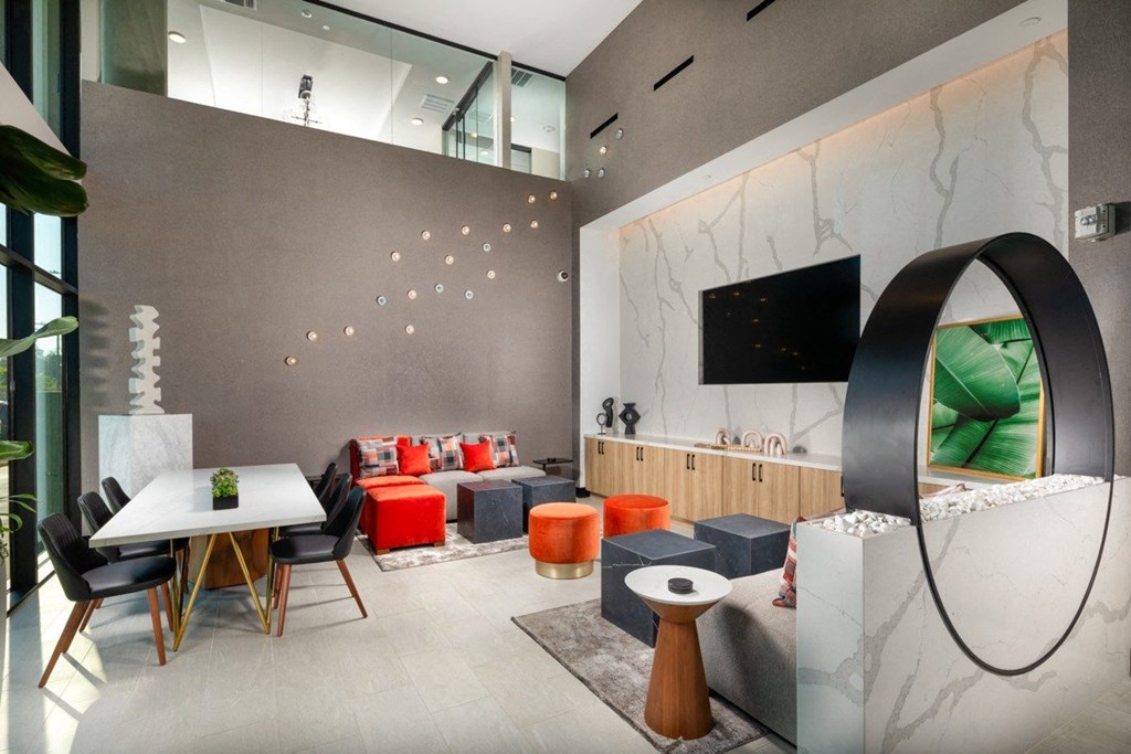A modern living room with a white dining table and black chairs.