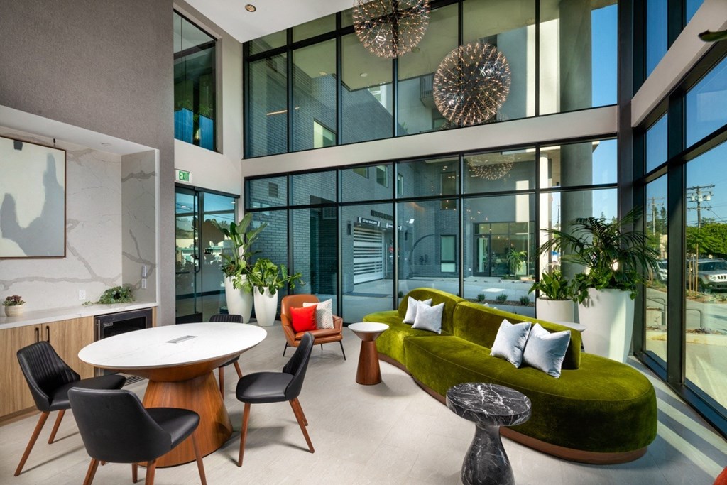 A modern living room with a green sofa and a round table.
