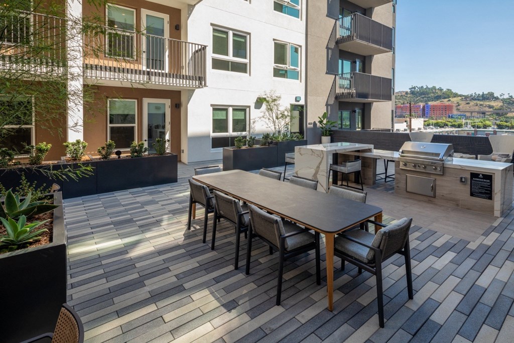 A patio with a table and chairs is surrounded by buildings.
