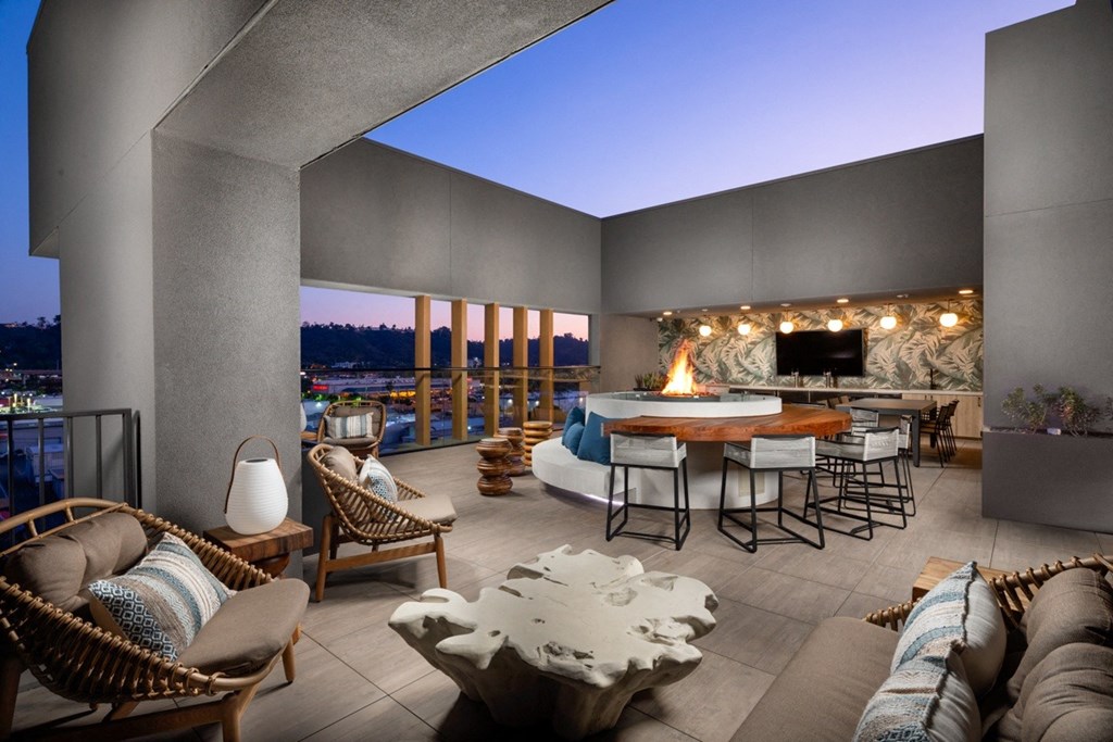 A modern outdoor living space with a fireplace and comfortable seating.