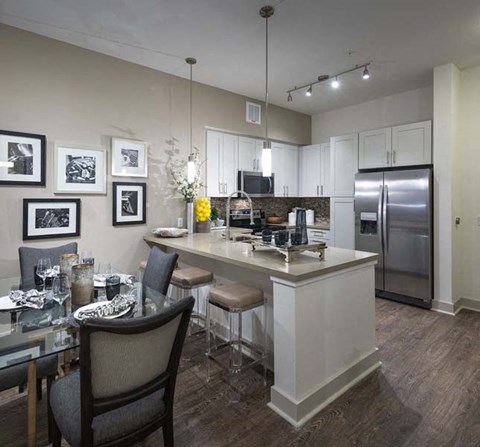 A modern kitchen with a dining table set for two.