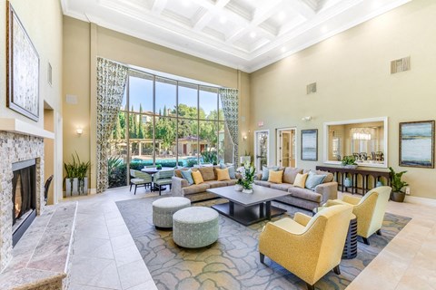 A spacious living room with a fireplace and a large window overlooking a garden.