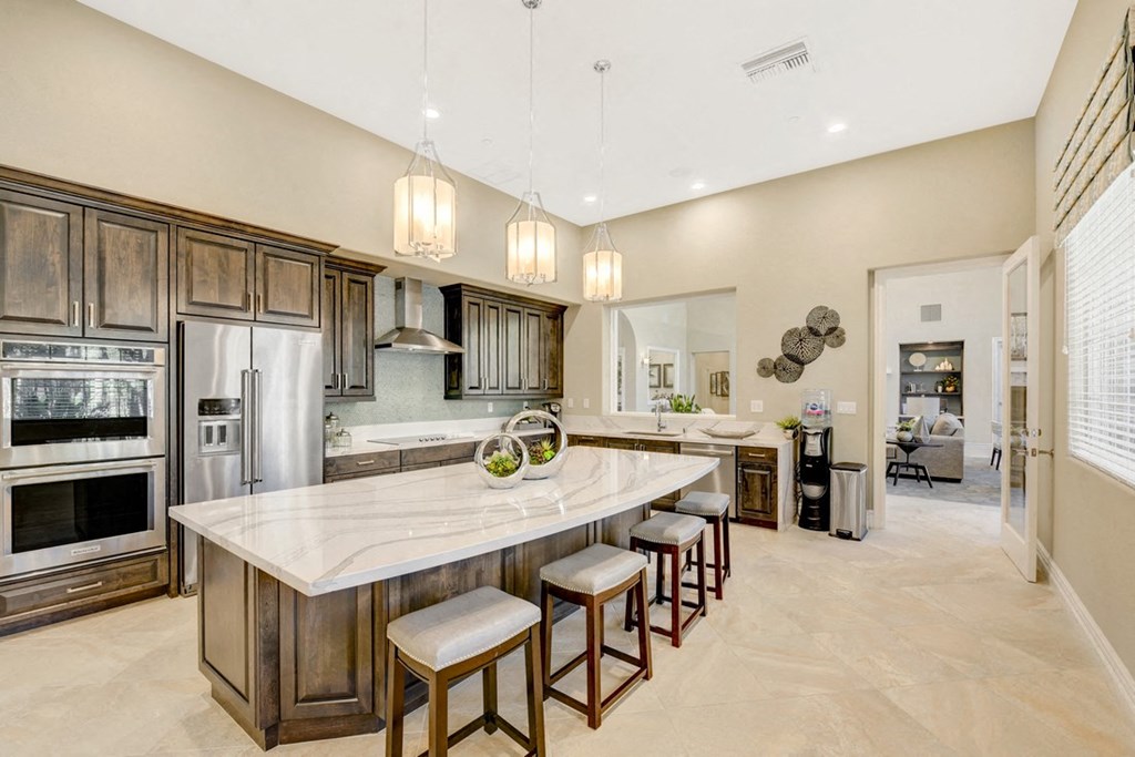 Clubhouse kitchen with a center island and bar stools.
