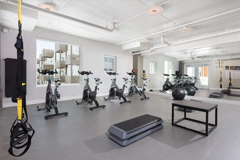A gym with exercise equipment and a bench.