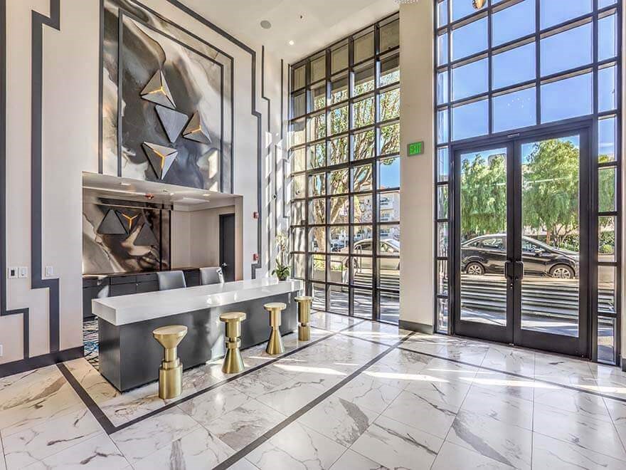 a lobby with a reception desk and glass doors