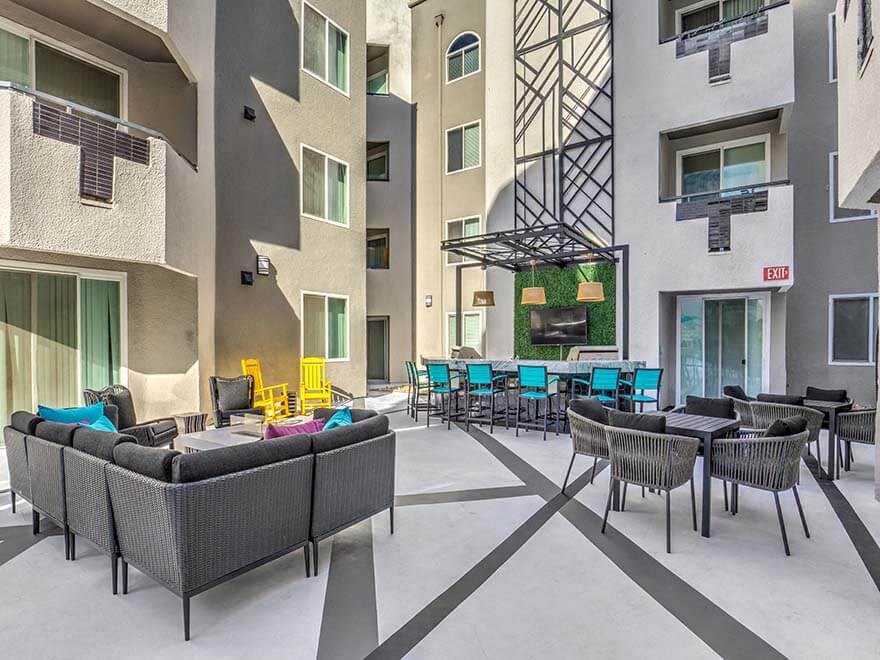 an open courtyard with tables and chairs in an apartment building