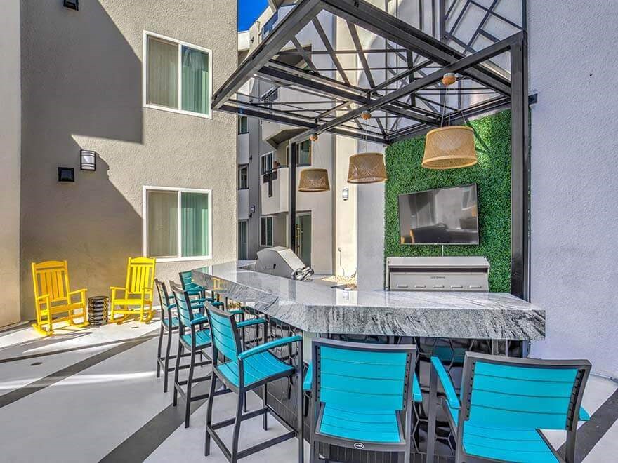 a patio with a bar and chairs and a television