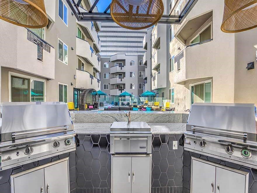 an outdoor kitchen with stainless steel appliances and a pool