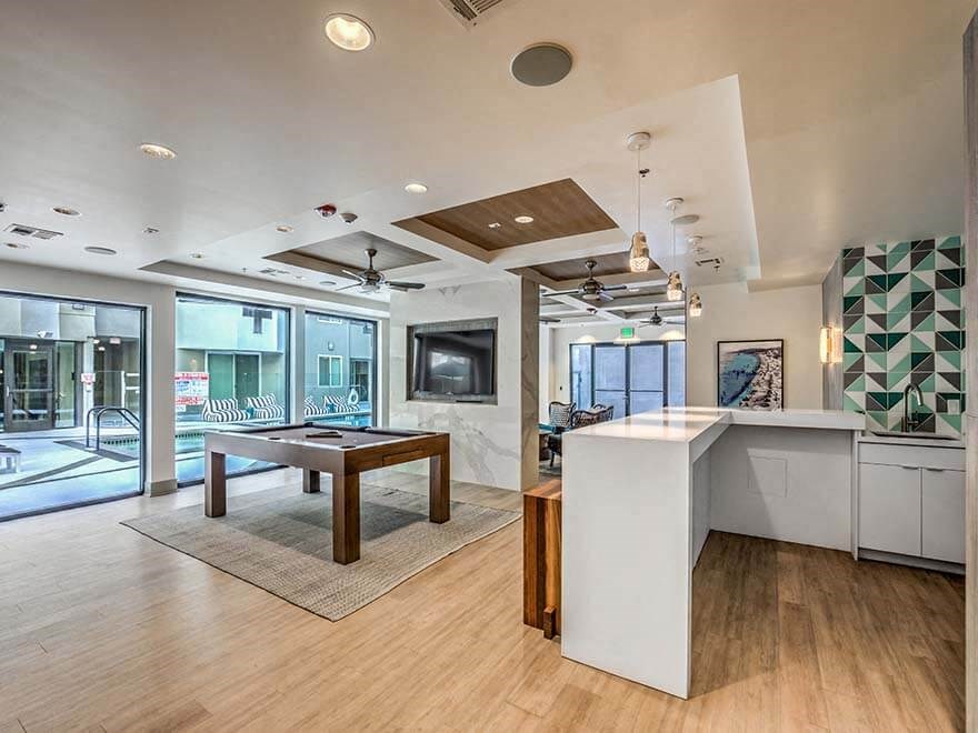 a room with a pool table and a kitchen