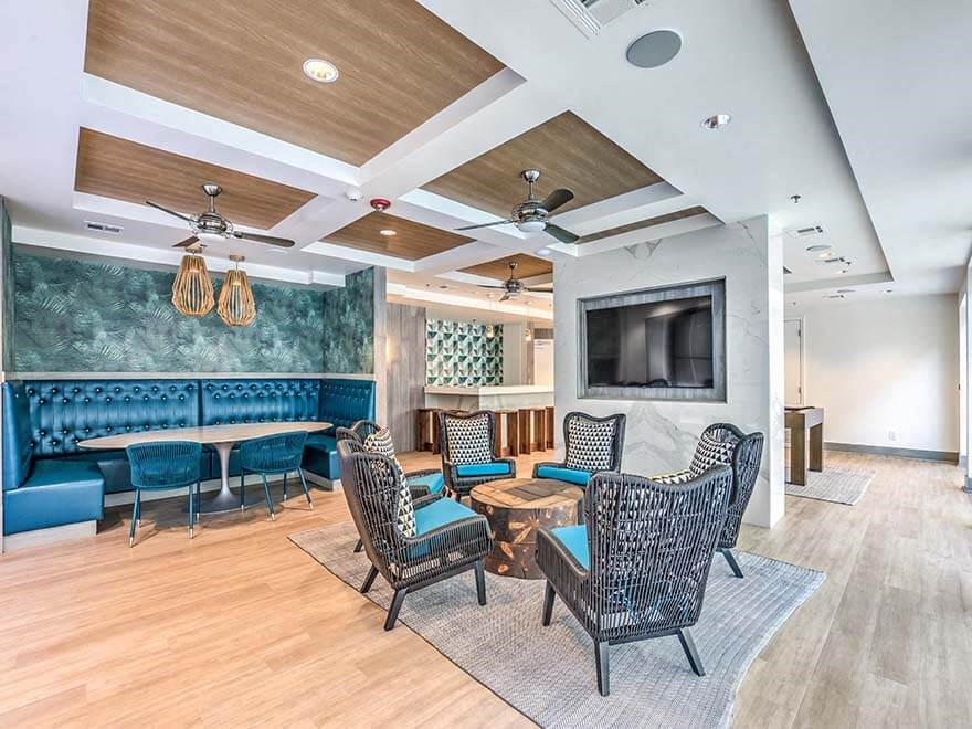 a lobby with tables and chairs and a television