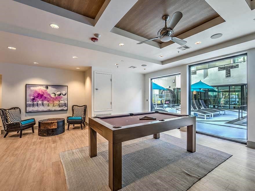 a pool table in a room with a ceiling fan
